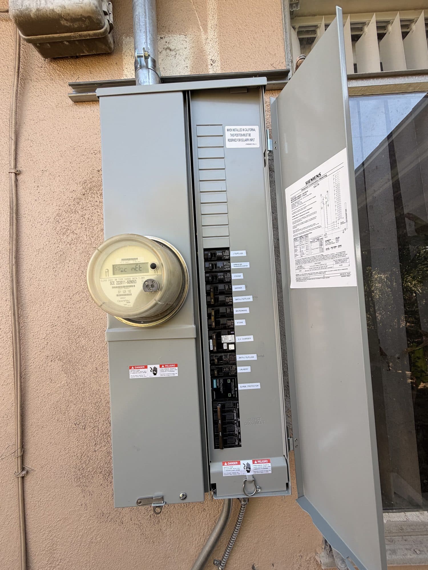 Newly installed main service panel with meter and breakers mounted on a stucco exterior wall